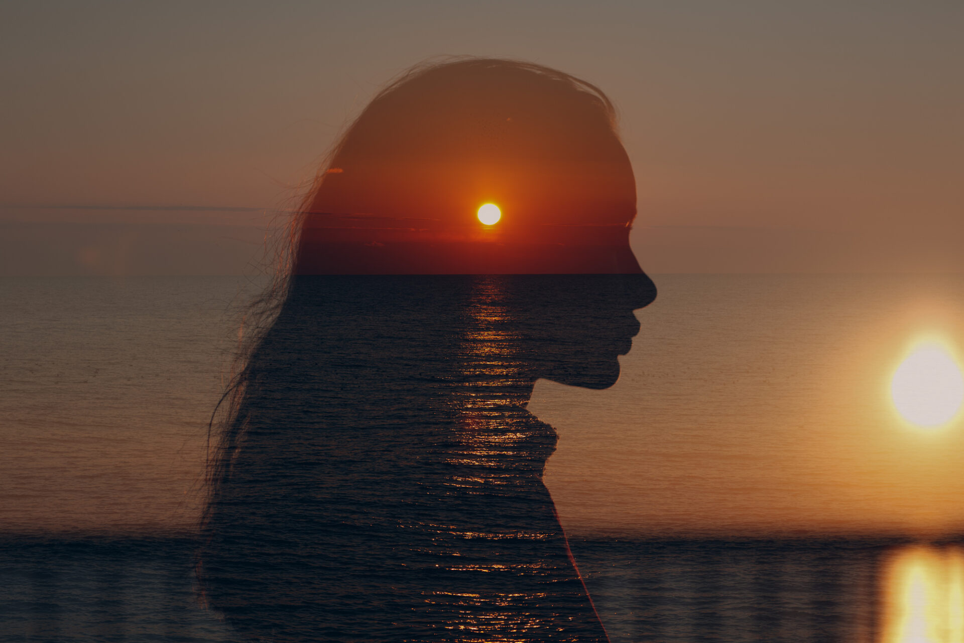 Young beautiful woman profile portrait at sea sunset.