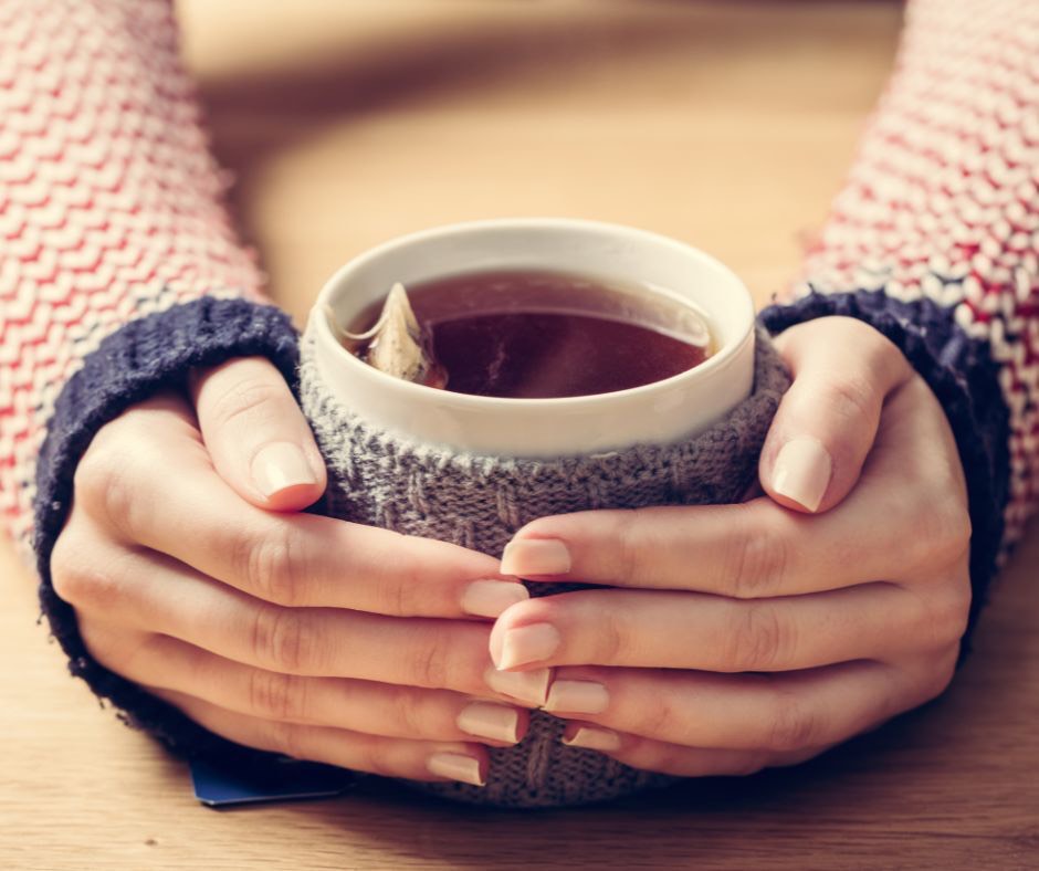 Woman with hands holding waem tea - why self love is important