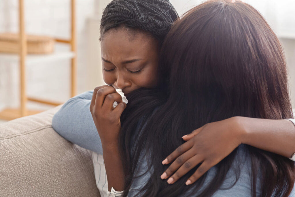 Woman hugging her crying friend after receiving bad news